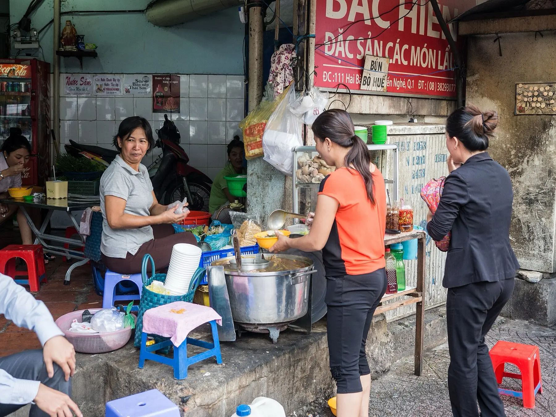Échoppe de cuisine de rue dans le vieux quartier de Hanoï, marmites et tabourets sur le trottoir